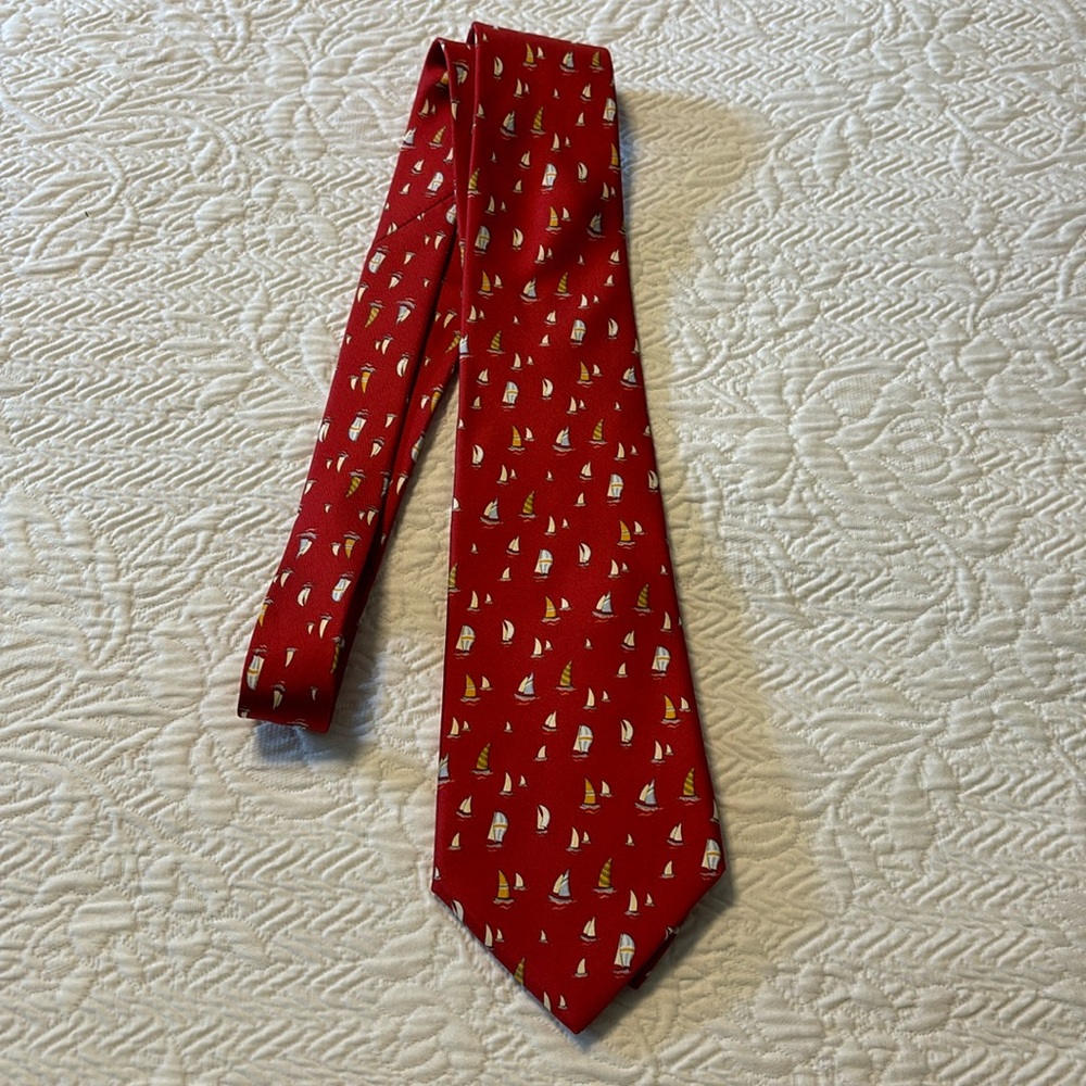 This is a Ferragamo tie in red with sailboats on it.